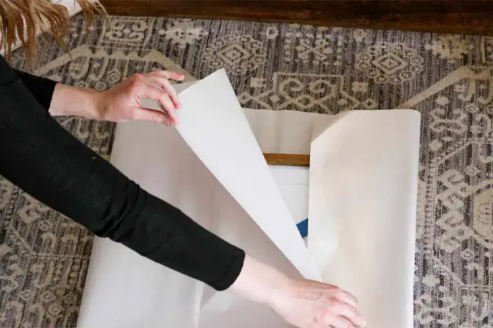 a woman packing a painting on floor