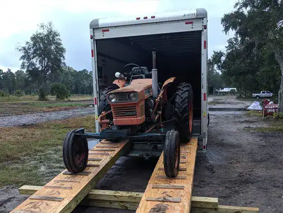 West Yellowstone MT movers loading a tractor into a moving truck somewhere in West Yellowstone MT